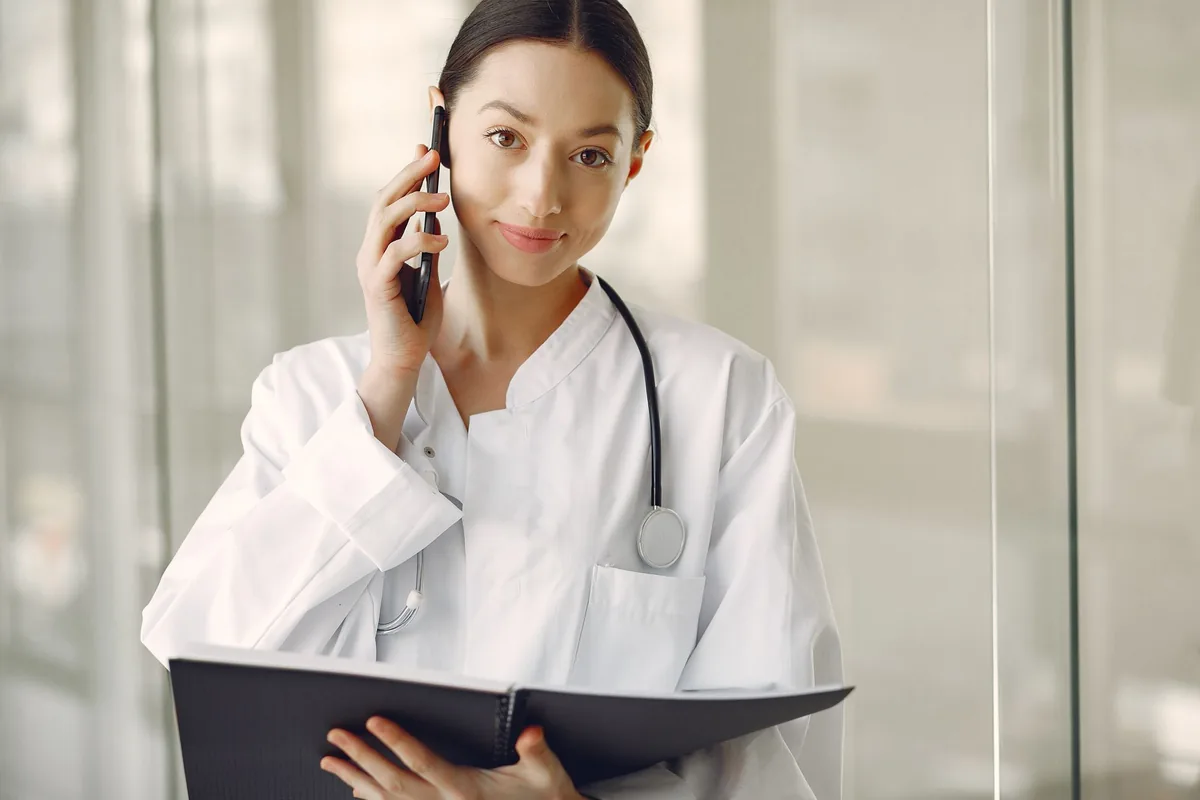 Doctora hablando por teléfono con una paciente en la clínica